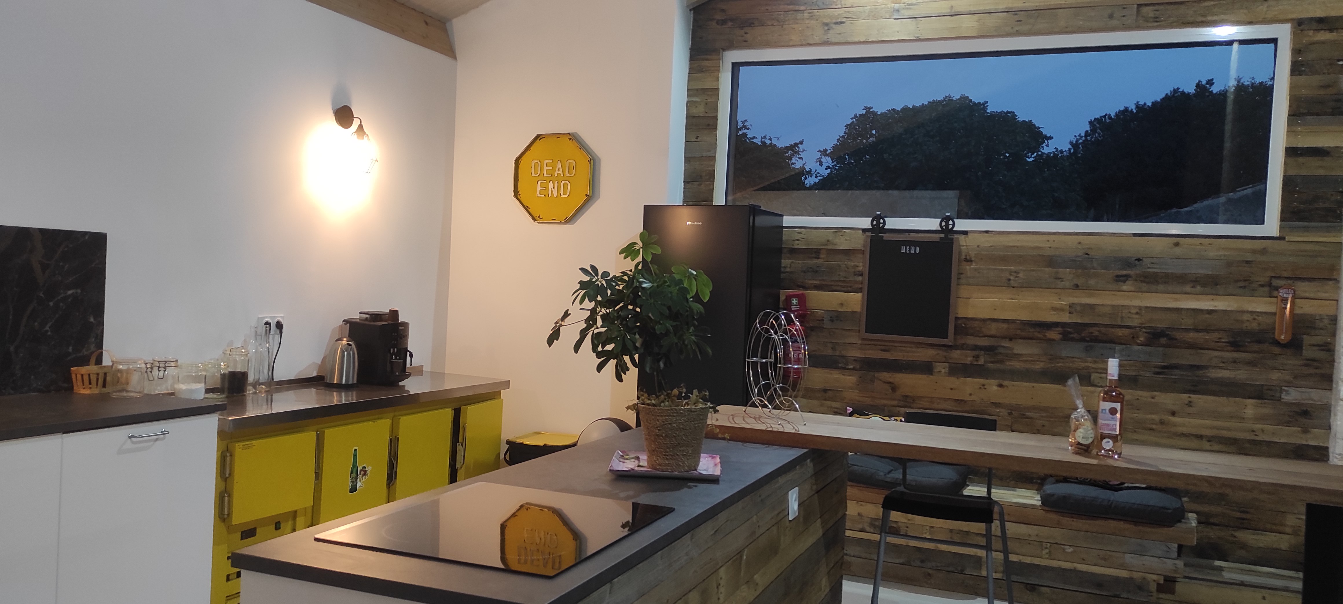 Coin cuisine, ilot central, mur ossature bois finition intérieur palettes.