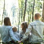 famille assise de dos dans la forêt